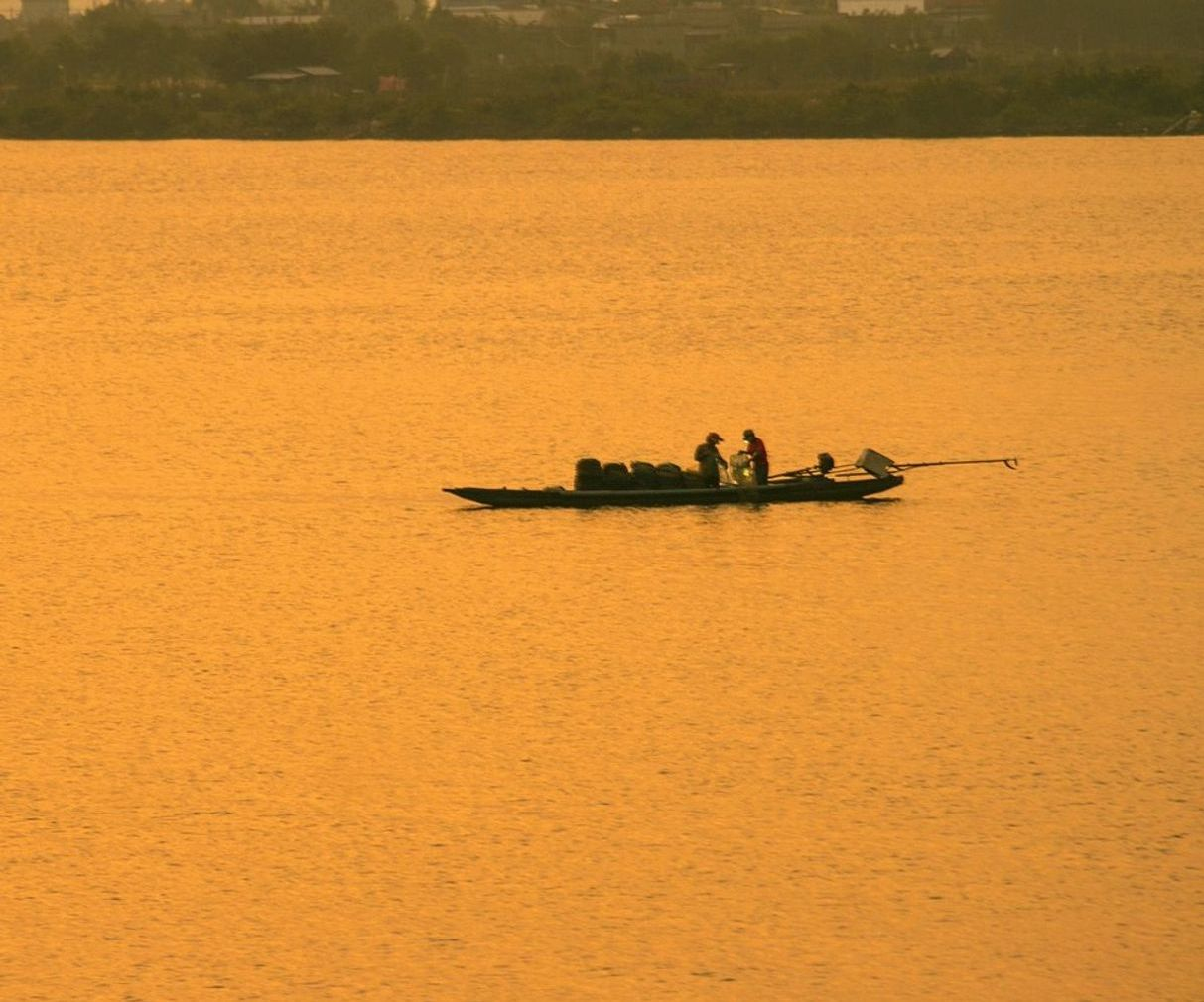 Pescador preparando isca com vista para as montanhas ao fundo